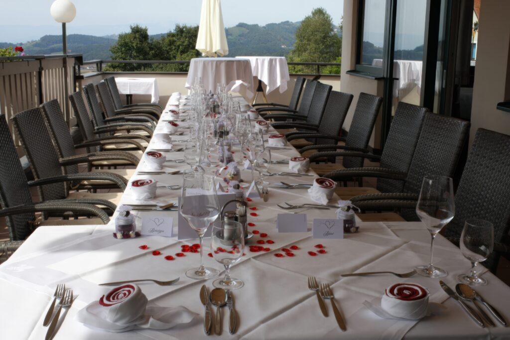 Eleganter gedeckter Tisch für eine festliche Veranstaltung auf einer Terrasse mit Aussicht.