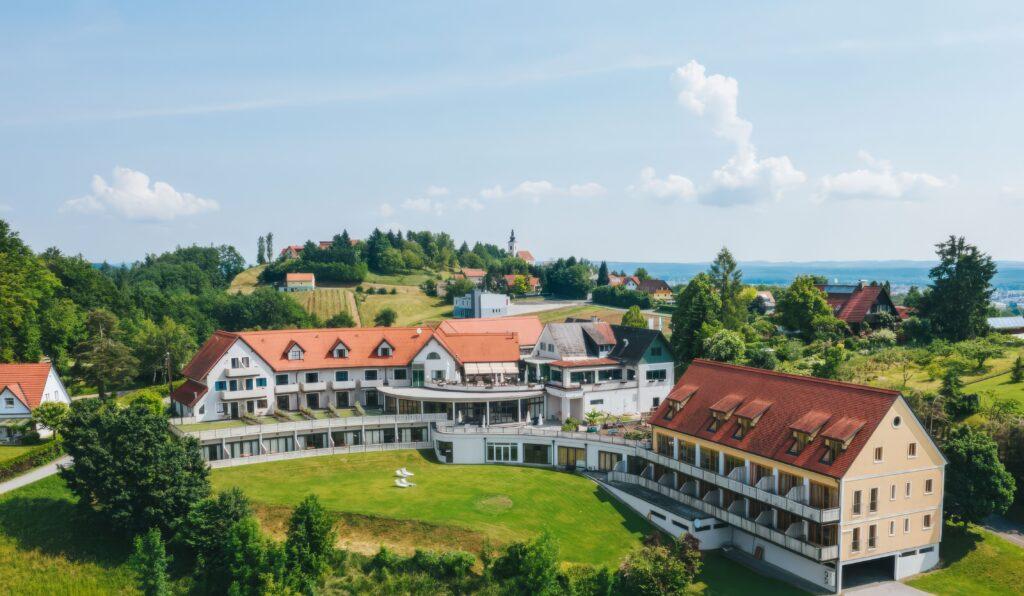Luftaufnahme eines malerischen Hotels mit roten Dächern und umgeben von grüner Landschaft