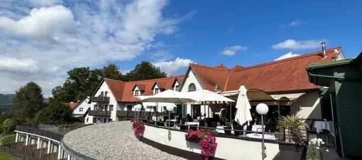 Schönes Hotel mit Terrasse und Sonnenschirmen unter blauem Himmel